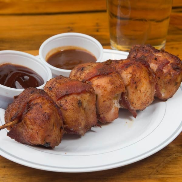 Yazoo BBQ's bacon-wrapped chicken skewers with two cups of barbecue sauce and a beer.